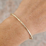 Gold bracelet with three diamond stones, on wrist handmade cuff by zoe alexandria jewellery